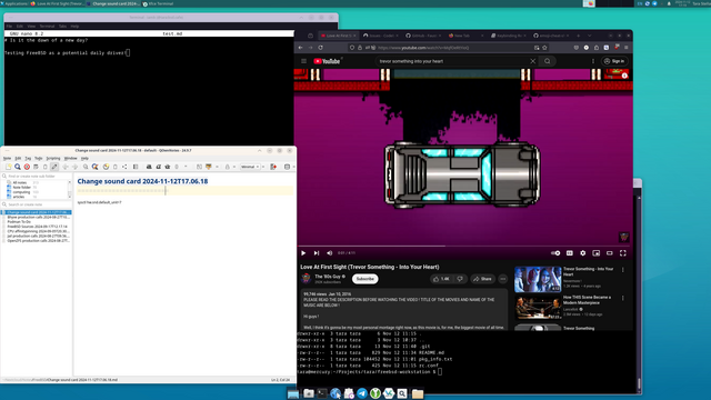 Screenshot of Tara's first attempt at running FreeBSD as a daily driver. The screenshot features FreeBSD 14.1-RELEASE-p5 with XFCE and a pink-based theme with tulips. In the foreground, Firefox is playing a song by Trevor Something on YouTube. QOwnNotes on the left side is Tara's favourite way of taking notes. On the upper left is a terminal with nano, and on the bottom right is a terminal opened on a git project.  Notification icons on NextCloud and Telegram.