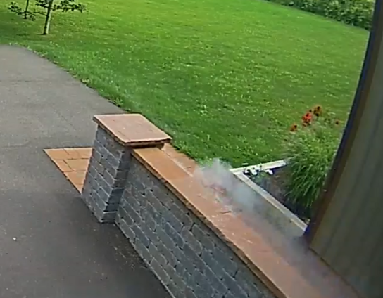 Splash of gray powder from outer space seen next to a walkway and grass, later determined to be a meteorite