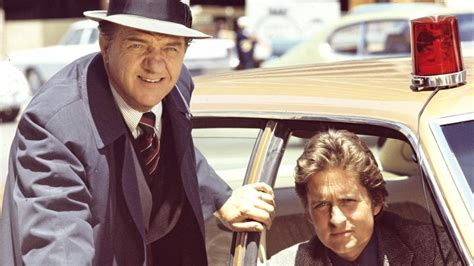 Snapshot from the TV series The Streets of San Francisco with Karl Malden standing outside of a yellow undercover squad car with a red bubble gum light on the roof, and with Michael Douglas sitting in the front passenger seat. Both gentlemen are looking towards the camera. Snapshot from the TV series The Streets of San Francisco with Karl Malden standing outside of a yellow undercover squad car with a red bubble gum light on the roof, and with Michael Douglas sitting in the front passenger seat. Both gentlemen are looking towards the camera.