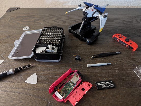 My table with a joycon opened up, a screwdriver set, and an arwing