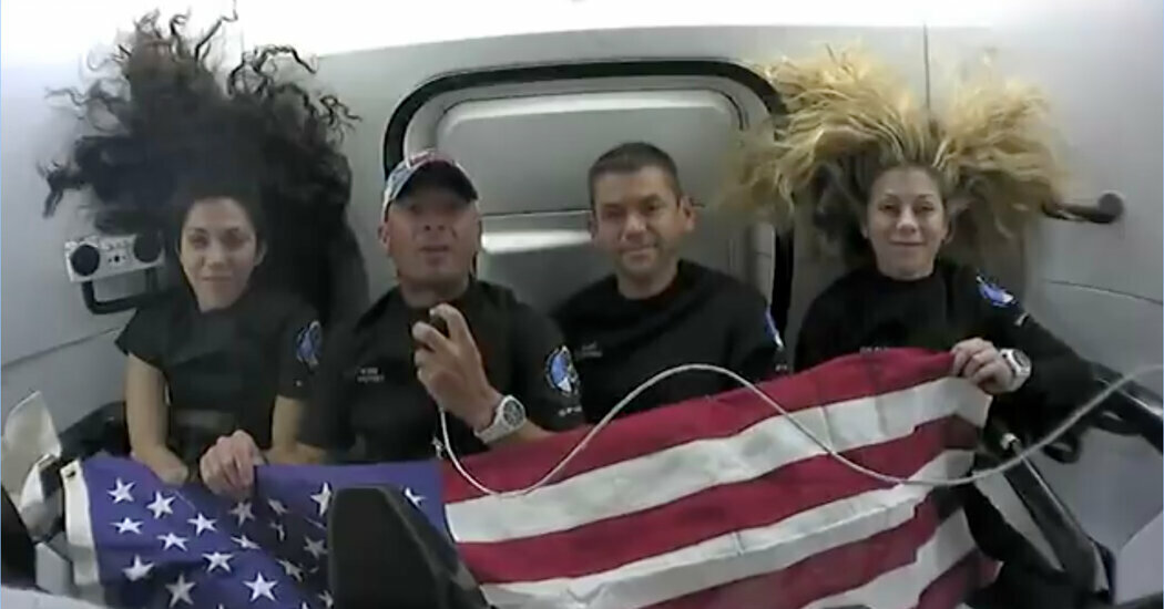 The Polaris Dawn crew during a video call on Wednesday. From left, Sarah Gillis, who oversees astronaut training at SpaceX; Scott Poteet, a retired U.S. Air Force pilot; Jared Isaacman, founder and chief executive of the company Shift4 Payments; and Anna Menon, a SpaceX engineer.