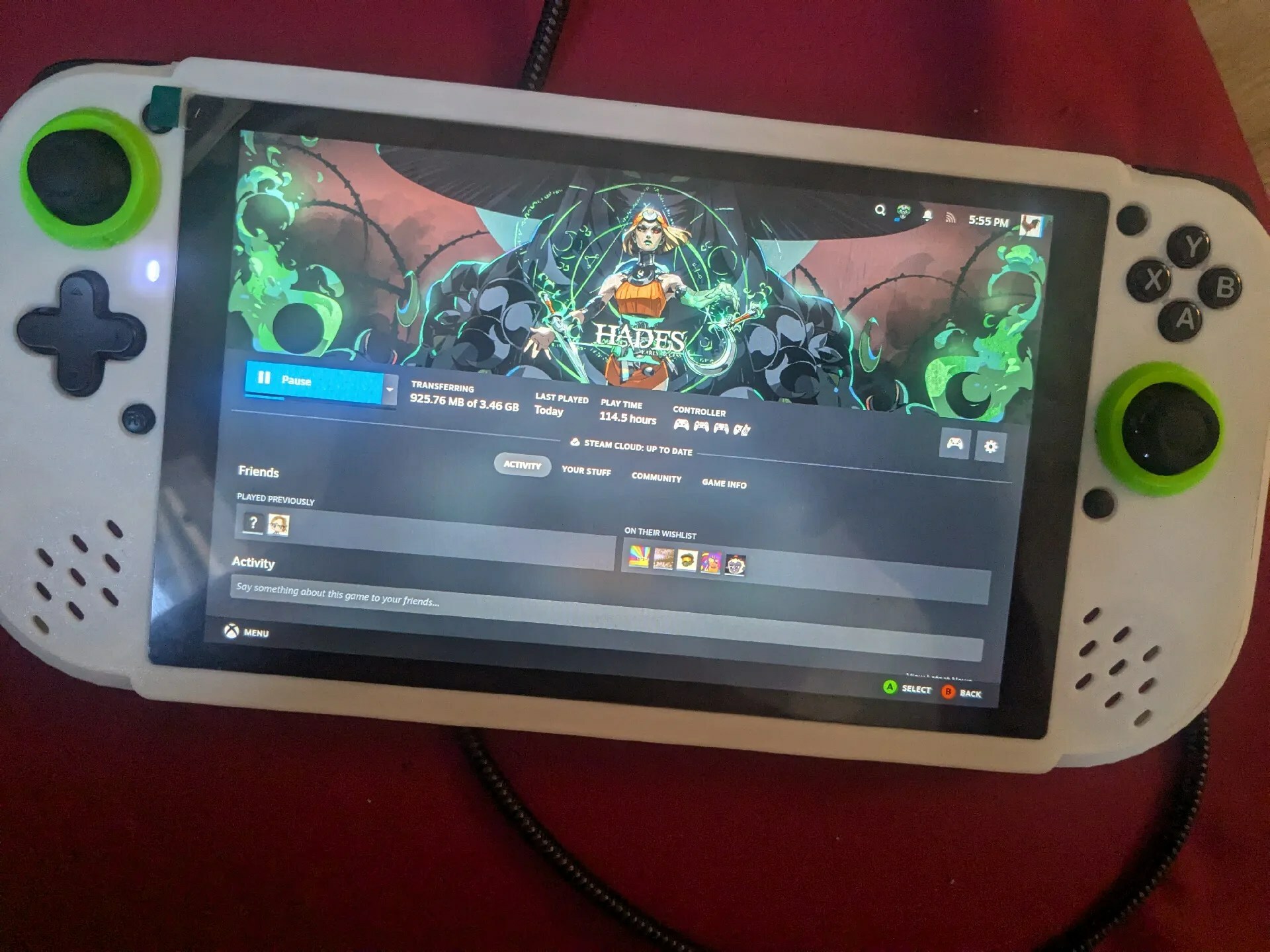 A white handheld with a centered screen and Xbox-style controllers flanking an 8" screen. Speaker grilles are visible below the controllers in the face of the device.