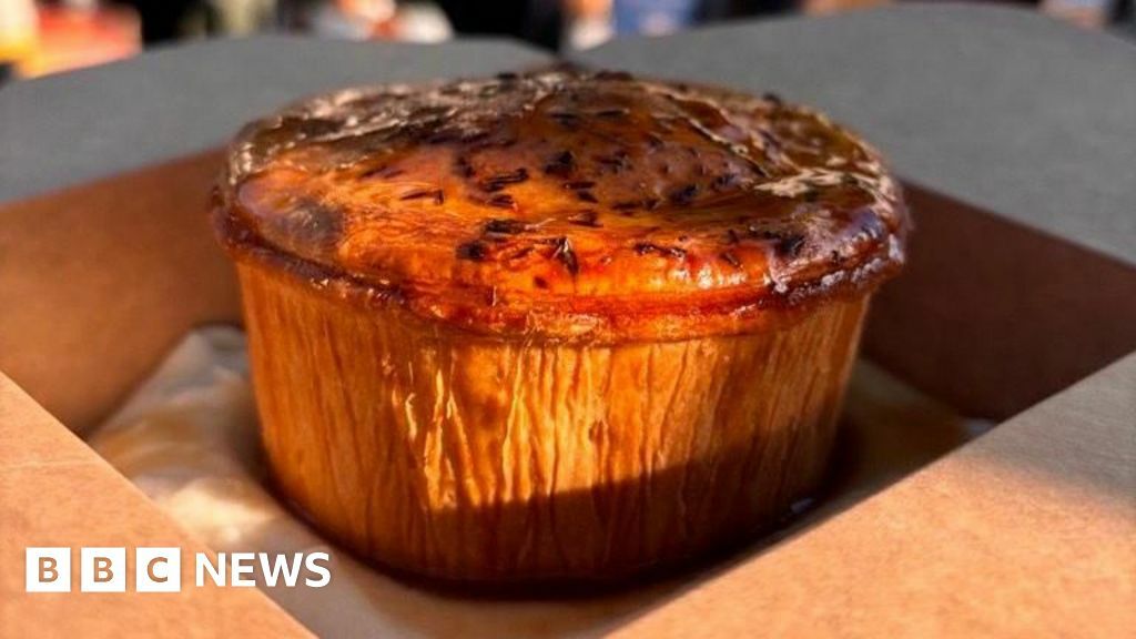 Pie and mash, covered with gravy, in a cardboard takeaway box