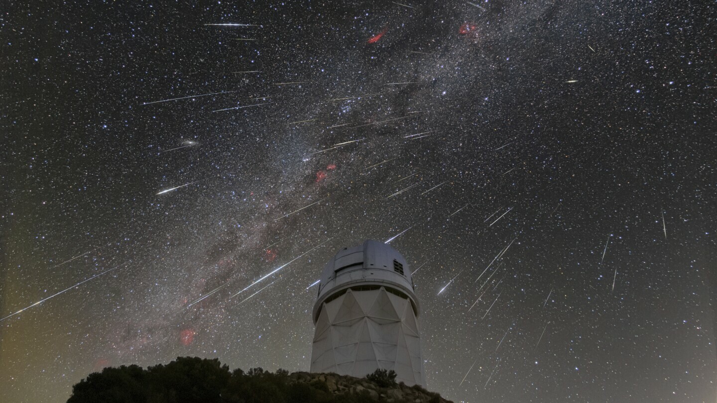 In this Dec. 14, 2023 photo provided by NOIRLab, meteors from the Geminid meteor shower streak across the sky above the Nicholas U. Mayall Telescope at Kitt Peak National Observatory (KPNO), a program of the National Science Foundation's NOIRLab, located about 56 miles (90 kilometers) southwest of Tucson in the Tohono O'odham Nation. (NSF/NOIRLab via AP, File)