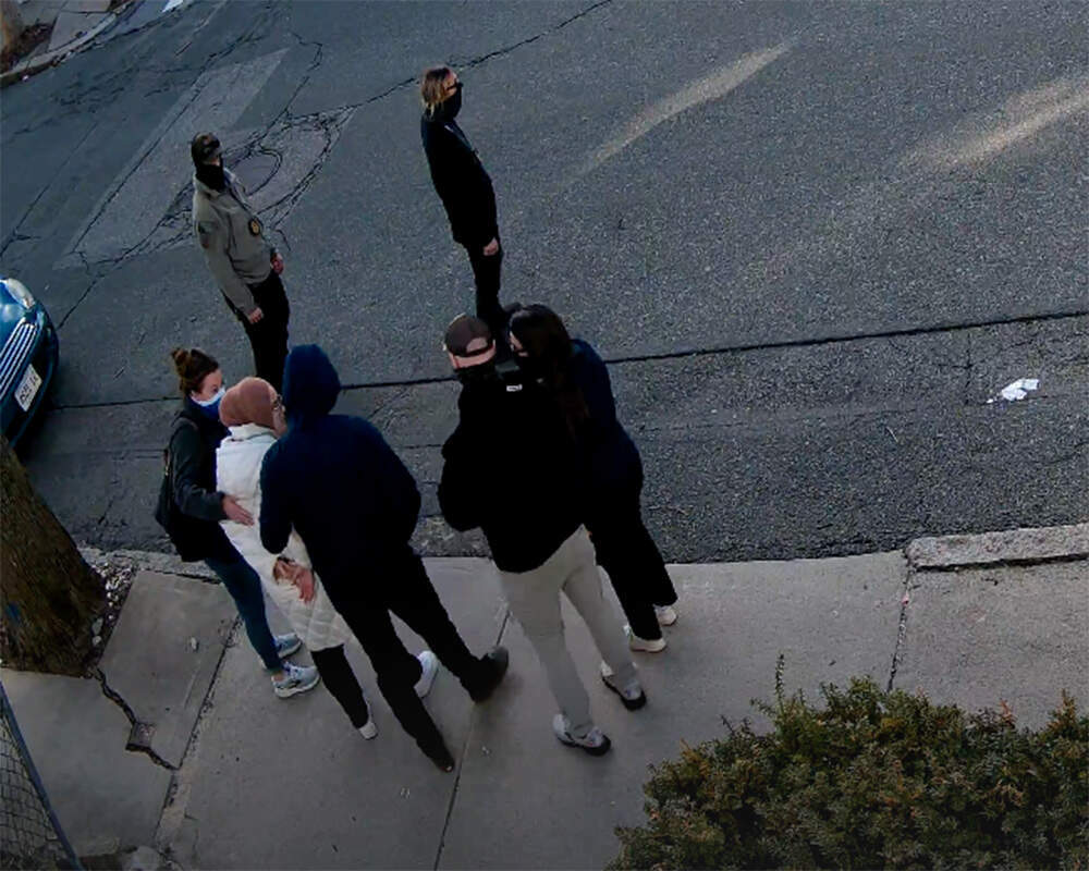 Screenshot of video from a neighbor's home security camera which appears to show federal immigration authorities placing Somerville resident and Tufts doctoral student Rumeysa Ozturk in custody on March 25. (Video courtesy of Michael Mathis)