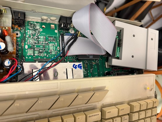 Custom made (and crimped) floppy ribbon and extended power cables inside my Atari St1024 , connected to the Gotek. 